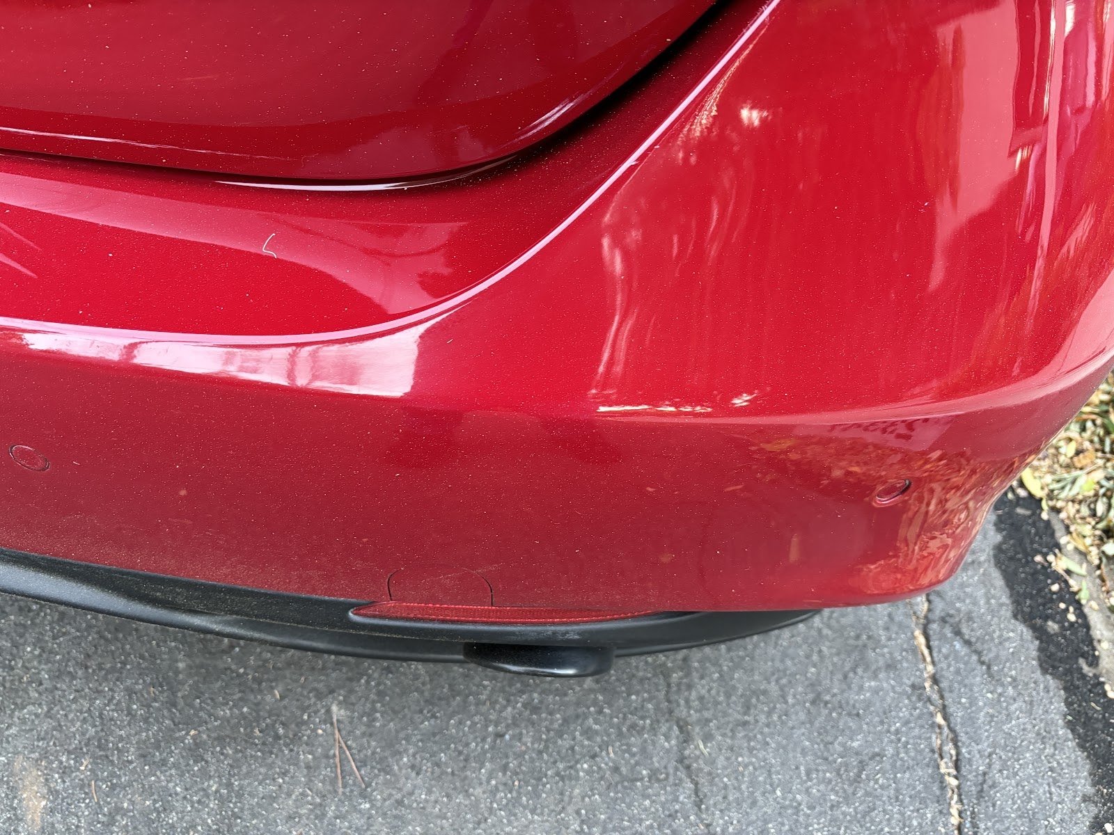 Close-up of a repaired rear bumper with parking sensors